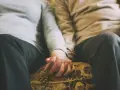 Mains jointes d'un couple qui ne se voit que le week-end, un moment précieux de connexion et de réconfort partagé.