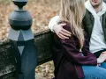 Un homme enlace tendrement une femme assise à ses côtés sur un banc. Un geste qui dit "comment dire je t'aime sans le dire".