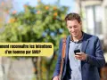 Un homme souriant regarde son téléphone, se demandant comment savoir ce qu'il pense de moi par SMS.