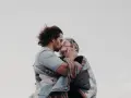 Un couple s'embrasse tendrement, enveloppé dans une couverture. Une belle illustration de comment trouver un mec et vivre un amour sincère.