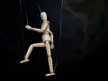 Marionnette de bois suspendue par des fils, se faisant désirer devant la Terre.