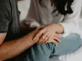 Mains jointes, une bague orne le doigt de la femme, symbole de l'effet boomerang en amour : ce qui est donné revient toujours.