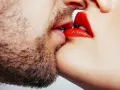 Un homme barbu et une femme aux lèvres rouges apprennent comment embrasser.