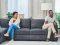 Un couple assis sur un canapé, dos à dos, l'air distant. Elle, les bras croisés, le regarde avec une expression de lassitude. Il, pensif, détourne le regard. Je l'aime mais je ne le supporte plus.