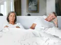 Couple au lit, elle est fâchée, lui semble préoccupé par une perte libido homme 60 ans.