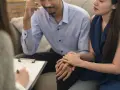 Un couple se tient la main lors d'une séance avec le meilleur psychologue pour couple, cherchant à améliorer leur relation.