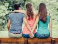 Trois personnes assises sur un banc, un homme entre deux femmes. Les mains des femmes se serrent derrière le dos de l'homme. Je ne le trouve pas beau mais il m'attire.