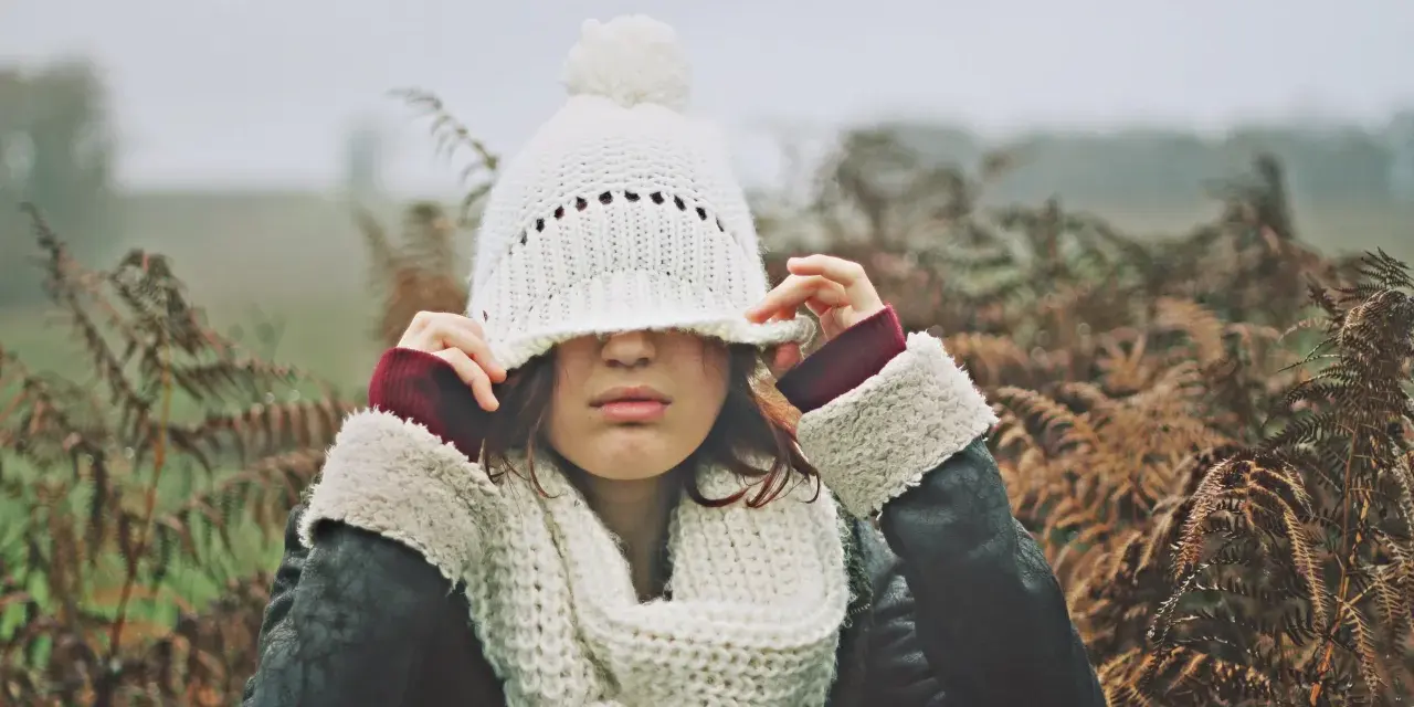 Une jeune femme, emmitouflée dans une écharpe et un bonnet blanc, ajuste son couvre-chef. Elle murmure "je t'aime", et son cœur répond "moi aussi".