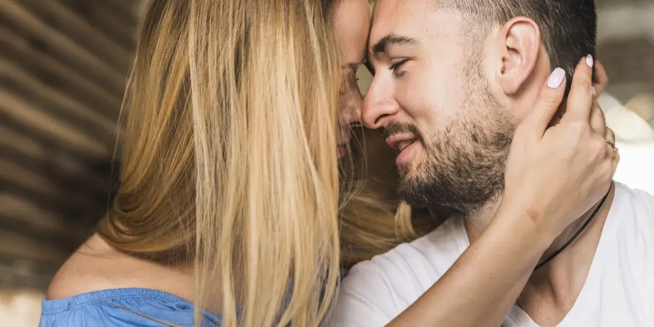 Un homme et une femme se rapprochent, leurs visages se touchant. C'est le début de comment un homme tombe amoureux.