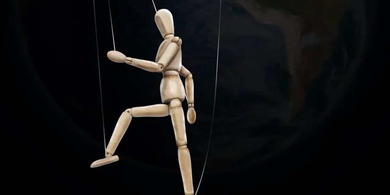 Marionnette de bois suspendue par des fils, se faisant désirer devant la Terre.