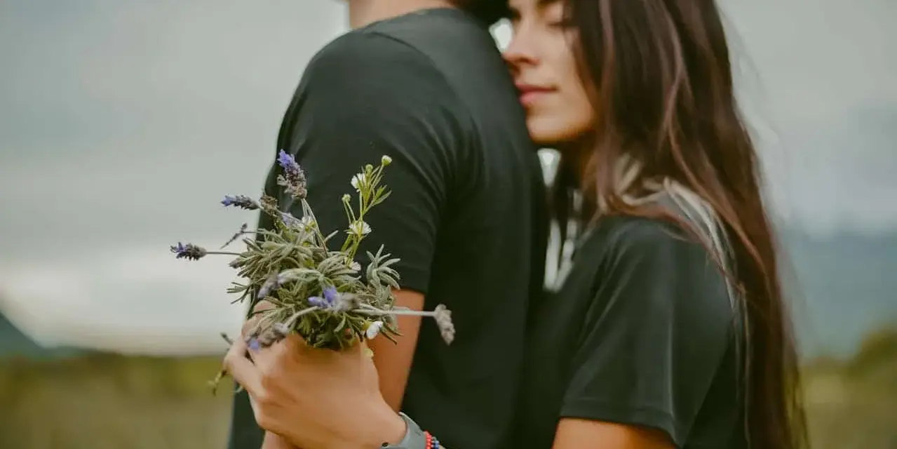 Un couple s'enlace tendrement, elle le serre fort, un bouquet de lavande à la main. Une image qui évoque la citation amour inconditionnel.