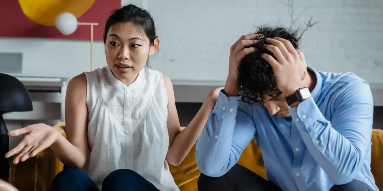 Une femme exprime sa frustration, se sentant incomprise. Son partenaire, accablé, se tient la tête. La communication est difficile dans leur couple.