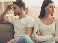 Un couple assis sur un canapé, dos à dos, visiblement en conflit. Elle croise les bras, l'air contrarié, comme s'il la prenait pour acquise.