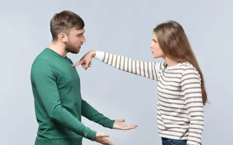 Une femme pointe du doigt un homme, exprimant son mécontentement. Ce geste symbolise les choses à ne pas accepter en couple, comme le manque de respect ou la communication agressive.