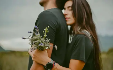 Un couple s'enlace tendrement, elle le serre fort, un bouquet de lavande à la main. Une image qui évoque la citation amour inconditionnel.