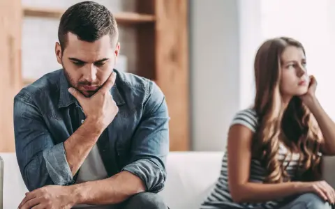 Un homme pensif, peut-être un homme qui trouve toujours des excuses, est assis à côté d'une femme qui regarde au loin, le couple semble distant.