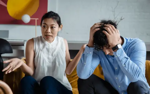 Une femme exprime sa frustration, se sentant incomprise. Son partenaire, accablé, se tient la tête. La communication est difficile dans leur couple.
