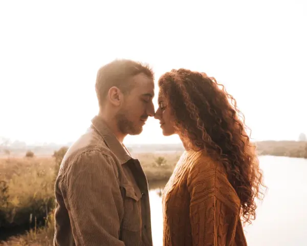 Un couple se regarde tendrement, nez à nez. Elle, aux cheveux roux bouclés, lui, au regard doux. Une scène intime qui suggère comment être unique aux yeux d'un homme.