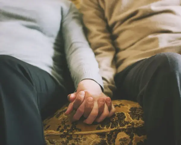 Mains jointes d'un couple qui ne se voit que le week-end, un moment précieux de connexion et de réconfort partagé.