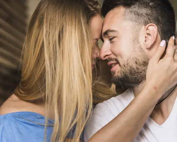 Un homme et une femme se rapprochent, leurs visages se touchant. C'est le début de comment un homme tombe amoureux.