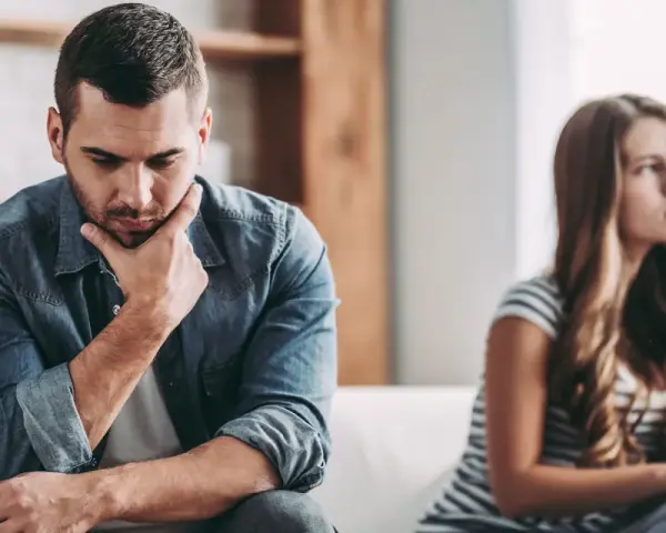 Un homme pensif, peut-être un homme qui trouve toujours des excuses, est assis à côté d'une femme qui regarde au loin, le couple semble distant.
