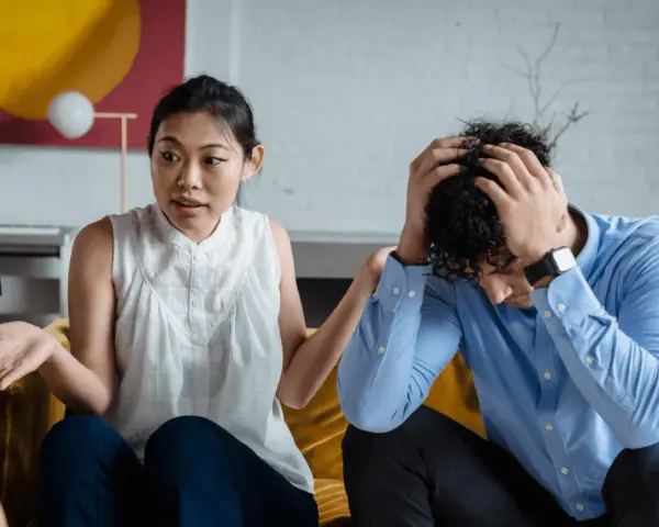 Une femme exprime sa frustration, se sentant incomprise. Son partenaire, accablé, se tient la tête. La communication est difficile dans leur couple.
