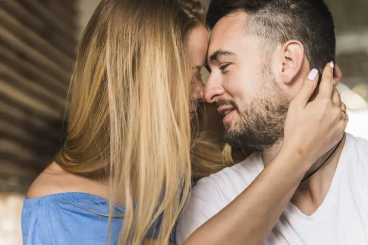 Un homme et une femme se rapprochent, leurs visages se touchant. C'est le début de comment un homme tombe amoureux.