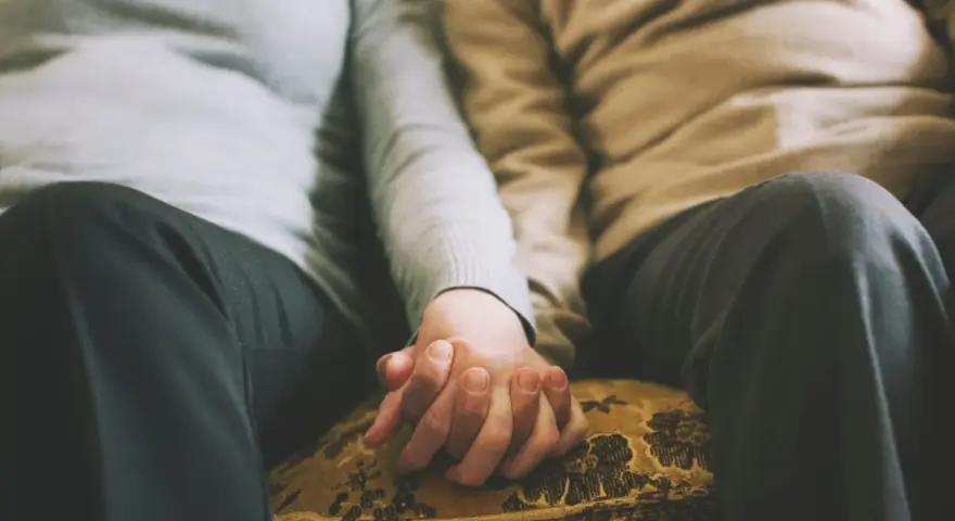 Mains jointes d'un couple qui ne se voit que le week-end, un moment précieux de connexion et de réconfort partagé.