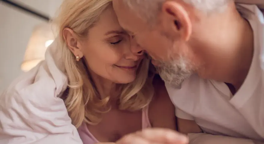 Couple âgé sous une couverture, évoquant la tendresse malgré la baisse de libido chez l'homme de 50 ans.