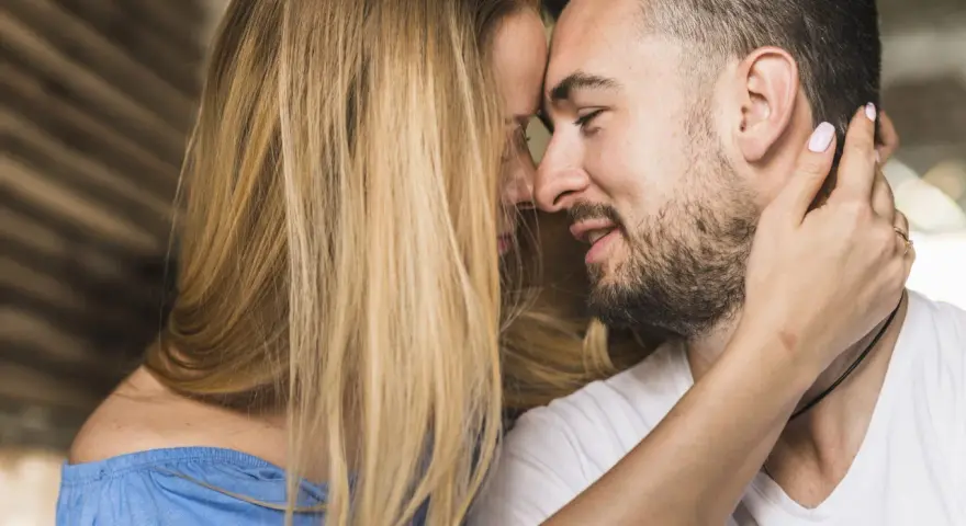Un homme et une femme se rapprochent, leurs visages se touchant. C'est le début de comment un homme tombe amoureux.