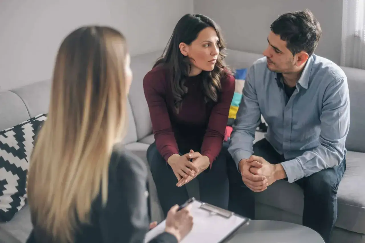 Un couple discute avec un th&eacute;rapeute, cherchant le meilleur psychologue pour couple afin de renforcer leur relation.