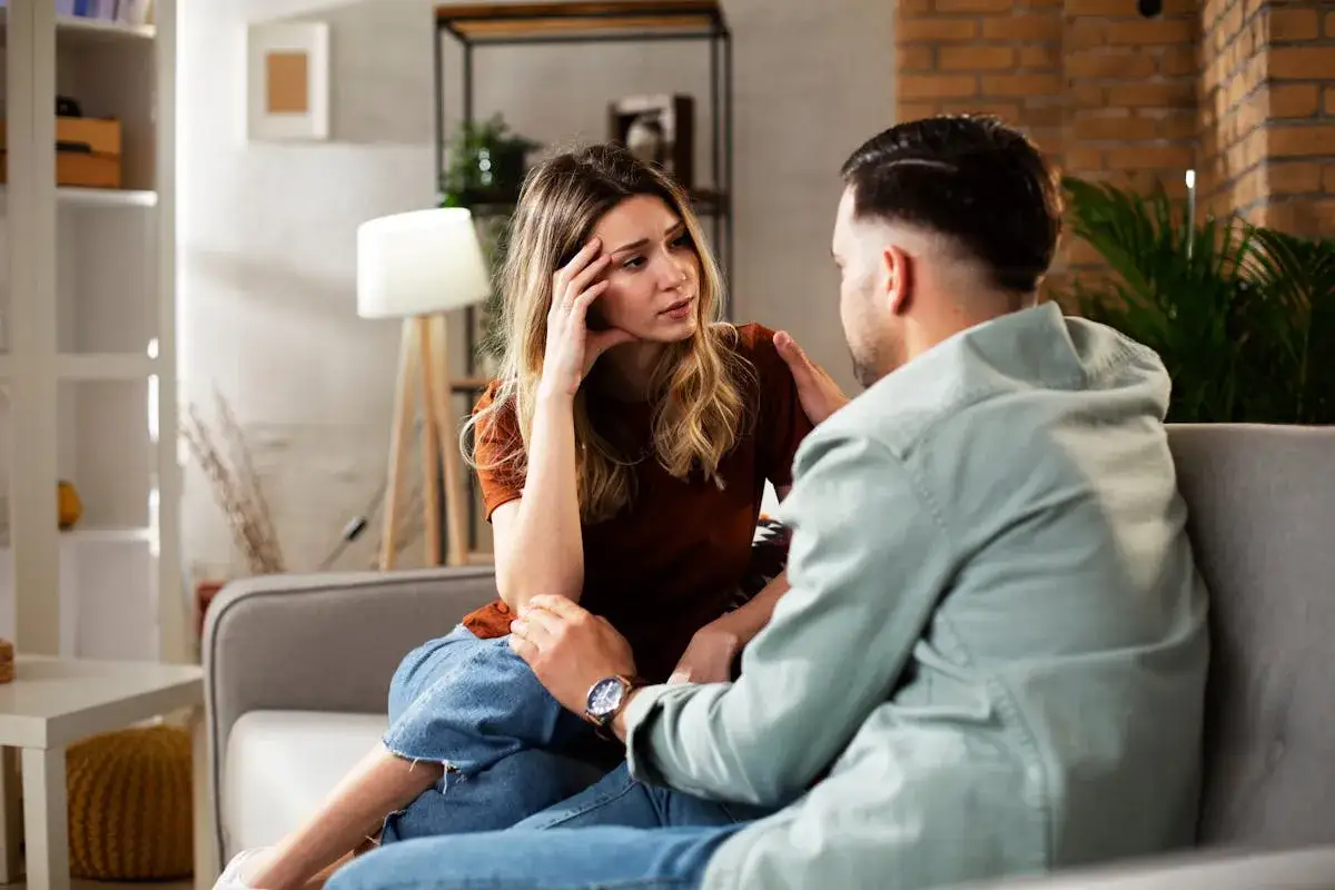 Un homme pose sa main sur l'&eacute;paule d'une femme, lui disant 