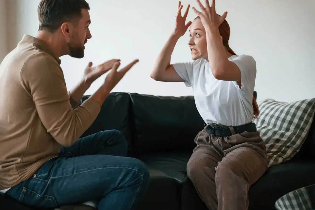Un couple en pleine dispute, illustrant un problème de communication psychologie. Les gestes et expressions montrent une tension palpable.
