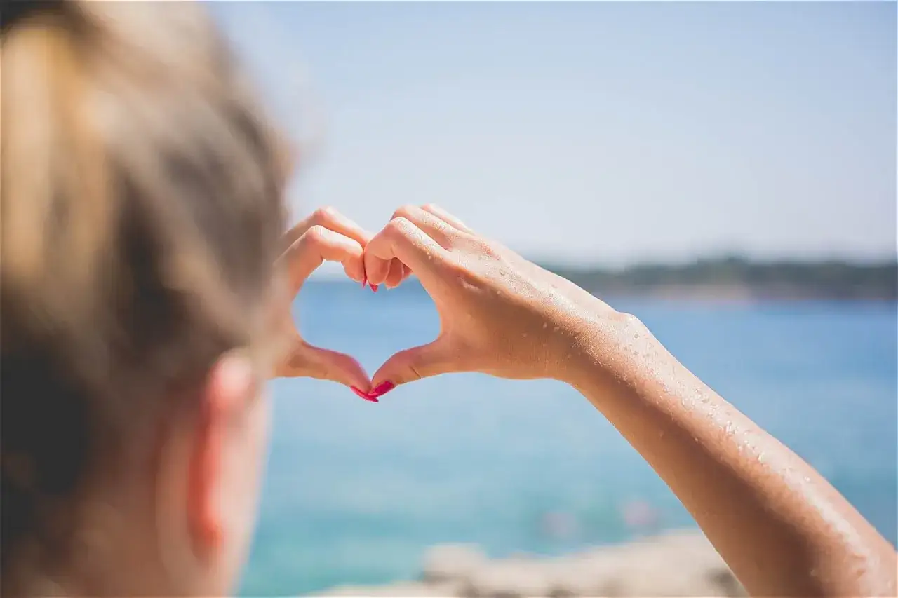 Maintenant, apr&egrave;s le premier rendez-vous, elle forme un c&oelig;ur avec ses mains mouill&eacute;es, regardant la mer.