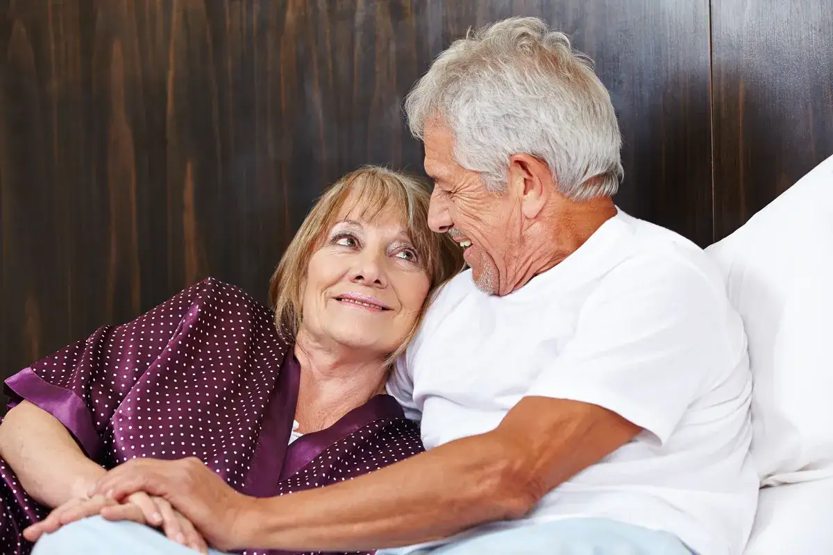 Couple &acirc;g&eacute; se tenant la main, souriant. Une image qui peut &eacute;voquer la perte de libido chez l'homme de 60 ans, mais aussi l'amour durable.