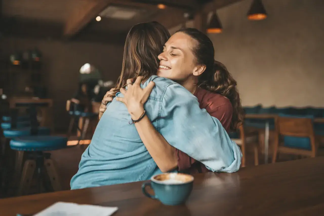 Deux femmes s'enlacent tendrement. Un geste d'amour et de pardon, peut-&ecirc;tre pour comment reconqu&eacute;rir sa femme apr&egrave;s l'avoir d&eacute;&ccedil;u.