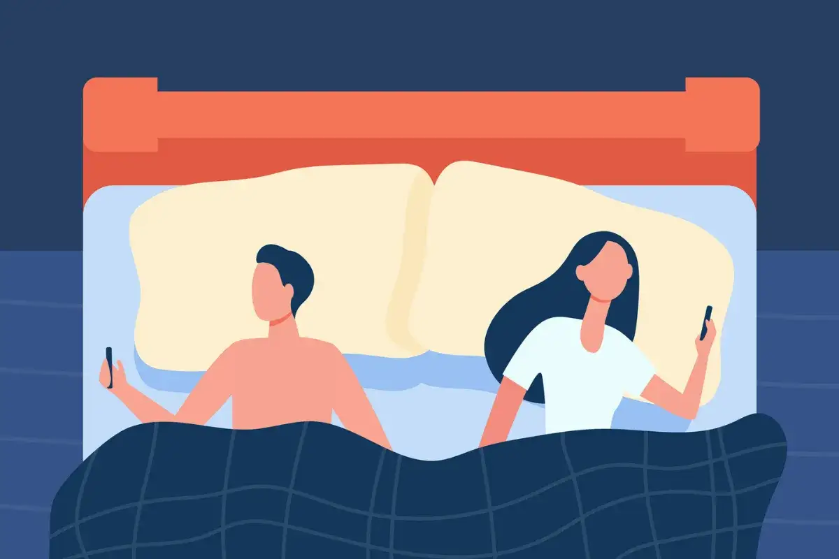 Couple dans un lit, chacun sur son t&eacute;l&eacute;phone. Leurs regards sont d&eacute;tourn&eacute;s, une illustration de la distance qui peut na&icirc;tre, et du d&eacute;sir de connexion, 
