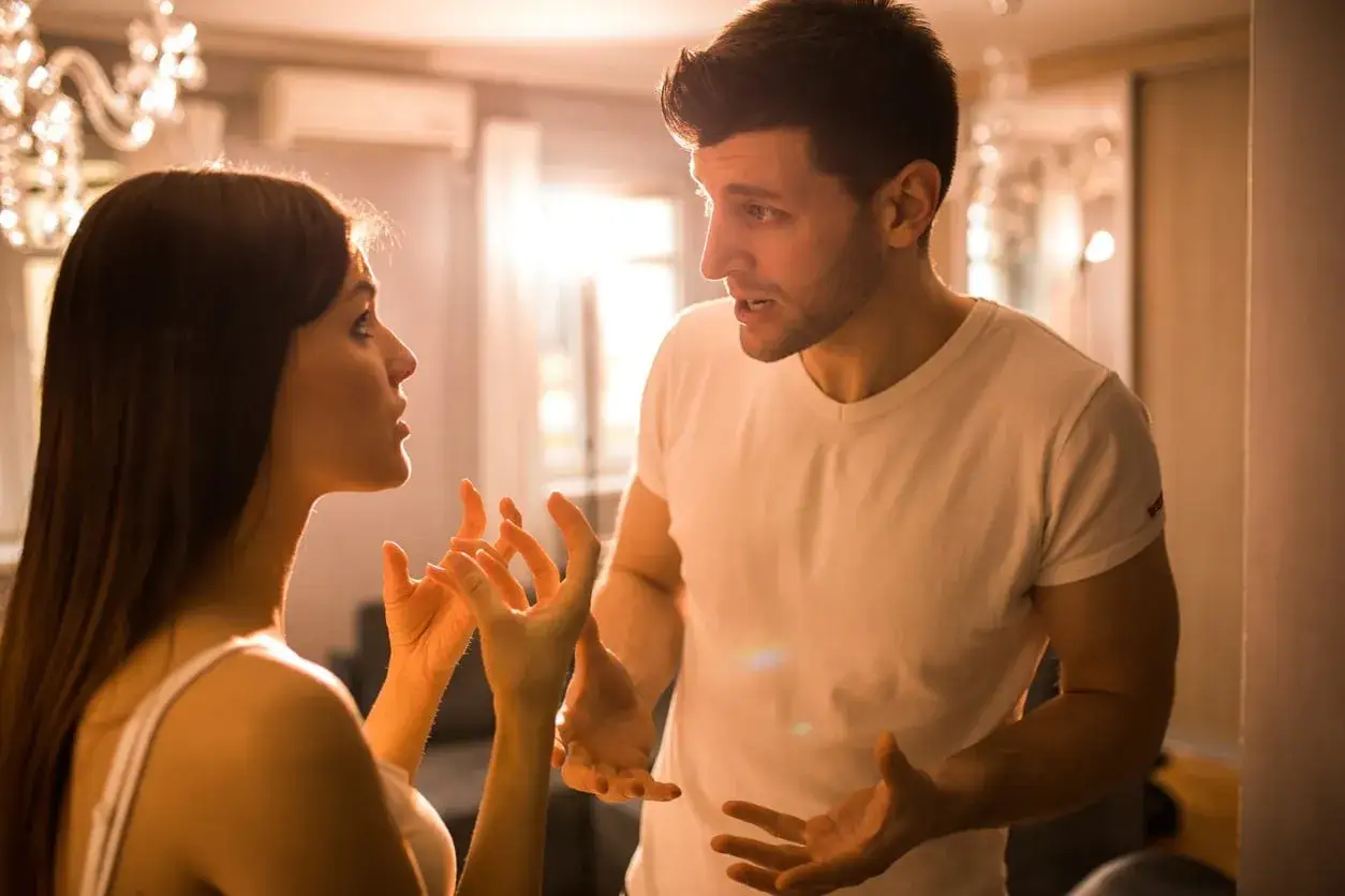 Un homme et une femme ont une conversation anim&eacute;e. Il tient &agrave; elle, mais n'est pas amoureux. Leurs mains sont lev&eacute;es, exprimant leurs &eacute;motions.