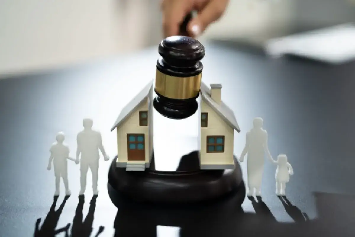 Marteau de juge sur une maison divisée, symbolisant un couple non cohabitant problème. Des silhouettes de famille se tiennent de chaque côté.