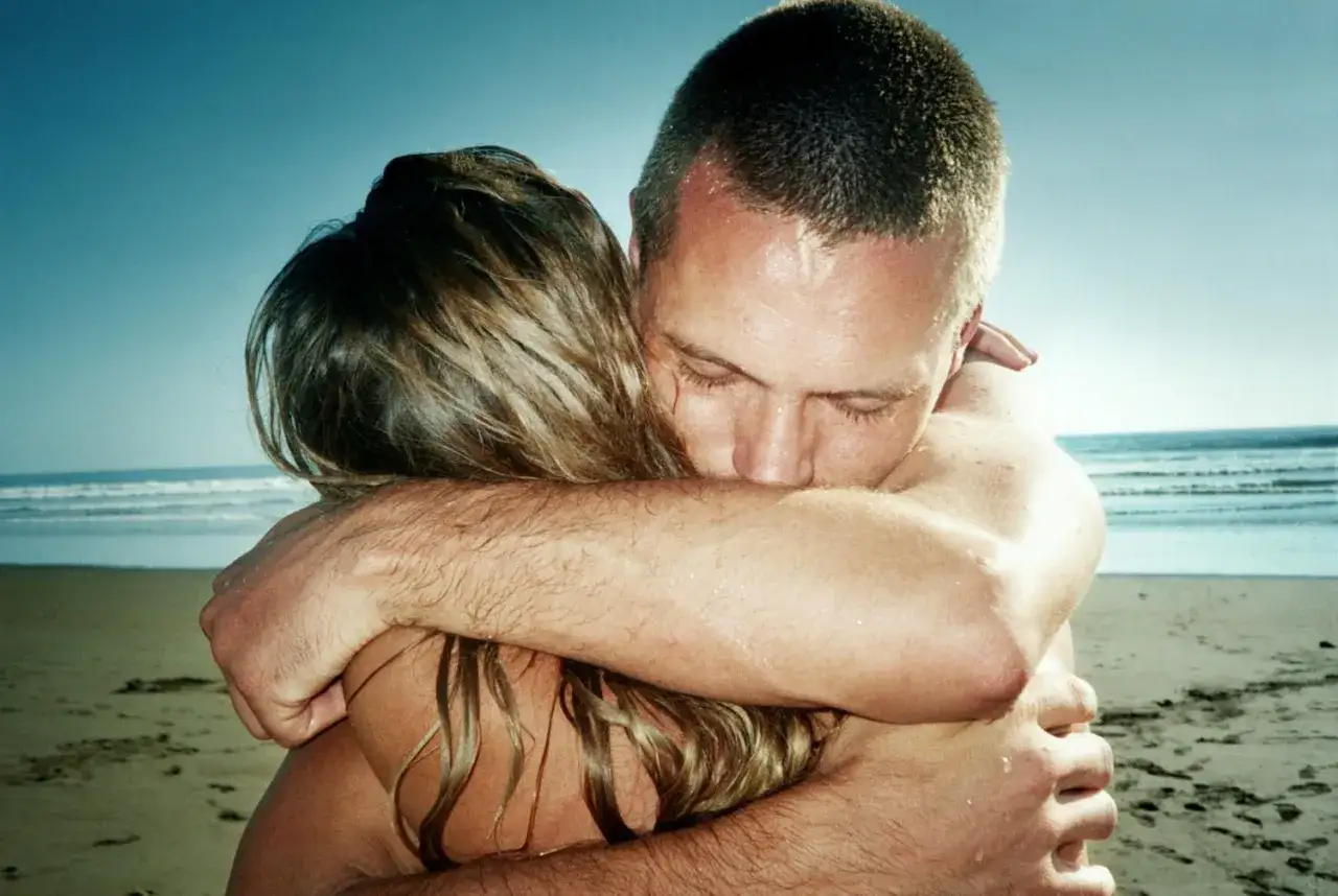 Un homme enlace une femme sur la plage. Un moment tendre pour comment réconcilier un couple, le pardon et l'amour retrouvé.