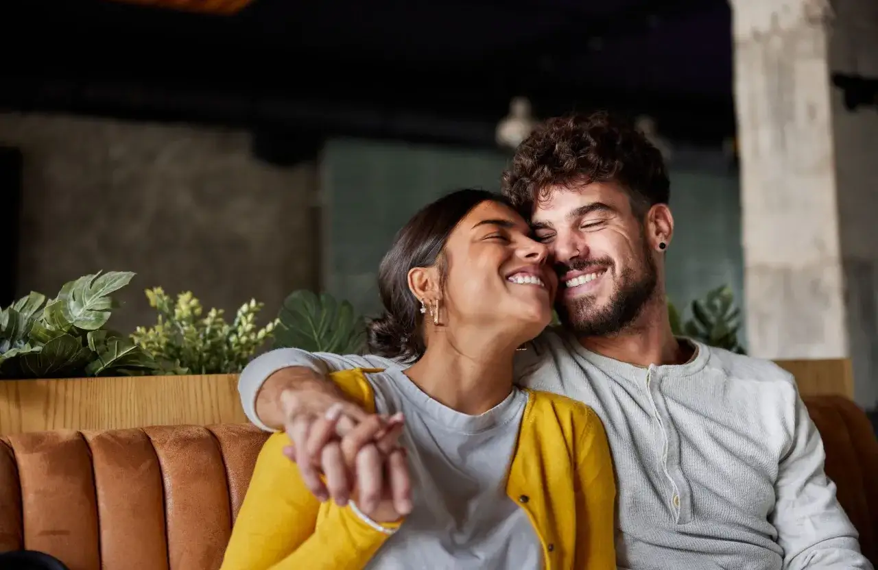 Un couple rayonnant de bonheur, main dans la main, partageant un moment de complicit&eacute;. Leurs sourires radieux t&eacute;moignent du vrai amour dans un couple.