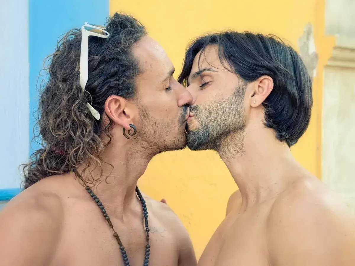 Deux hommes s'embrassent tendrement. Ce geste exprime l'amour et la connexion, une belle signification pour les hommes.