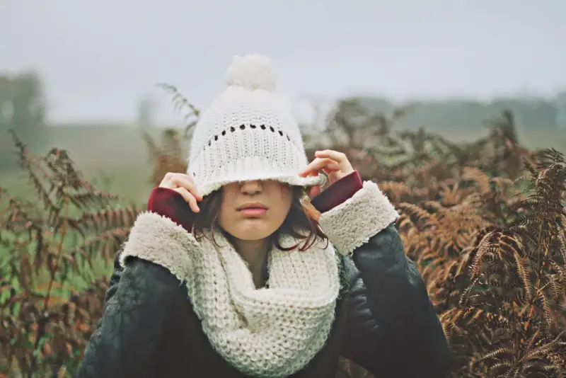Une jeune femme, emmitouflée dans une écharpe et un bonnet blanc, ajuste son couvre-chef. Elle murmure "je t'aime", et son cœur répond "moi aussi".